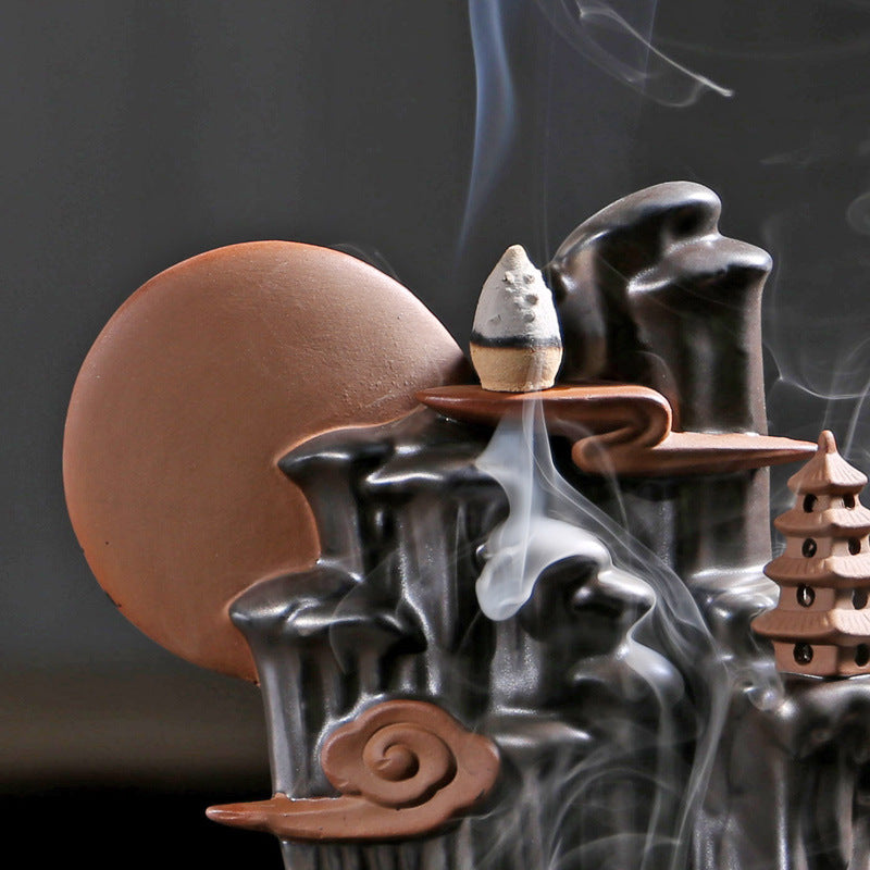 Sacred Moon Candle Co black backflow incense burner with detailed mountain and temple design releasing smoke