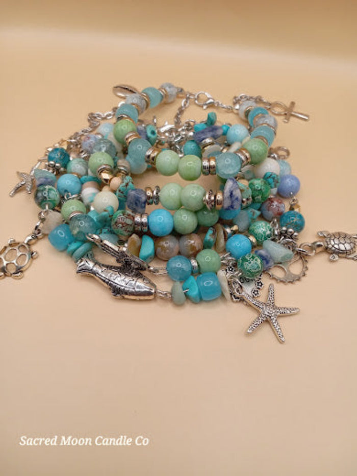 Bohemian beach crystal bracelet stack with turquoise beads and silver ocean-themed charms by Sacred Moon Candle Co