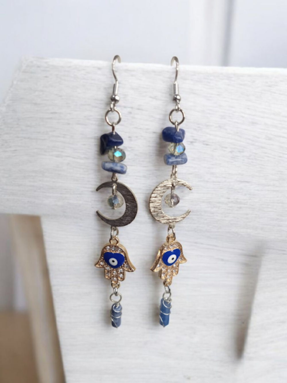 Sacred Moon Candle Co crescent moon hamsa earrings with blue stones and gold-tone hand charms