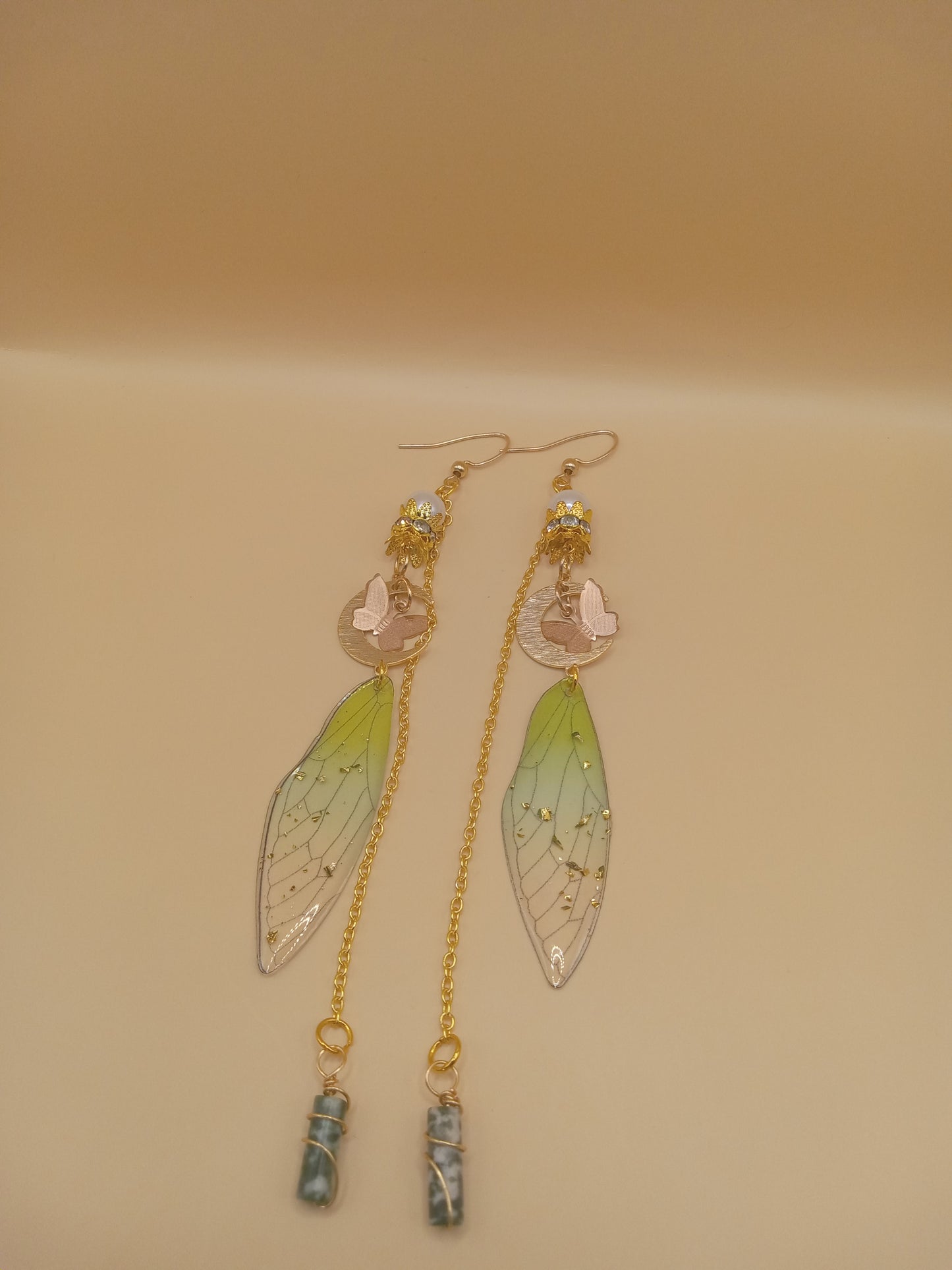 green fairy wing dangle earrings by Sacred Moon Candle Co featuring gold chains green gradient wings and marble stone drops
