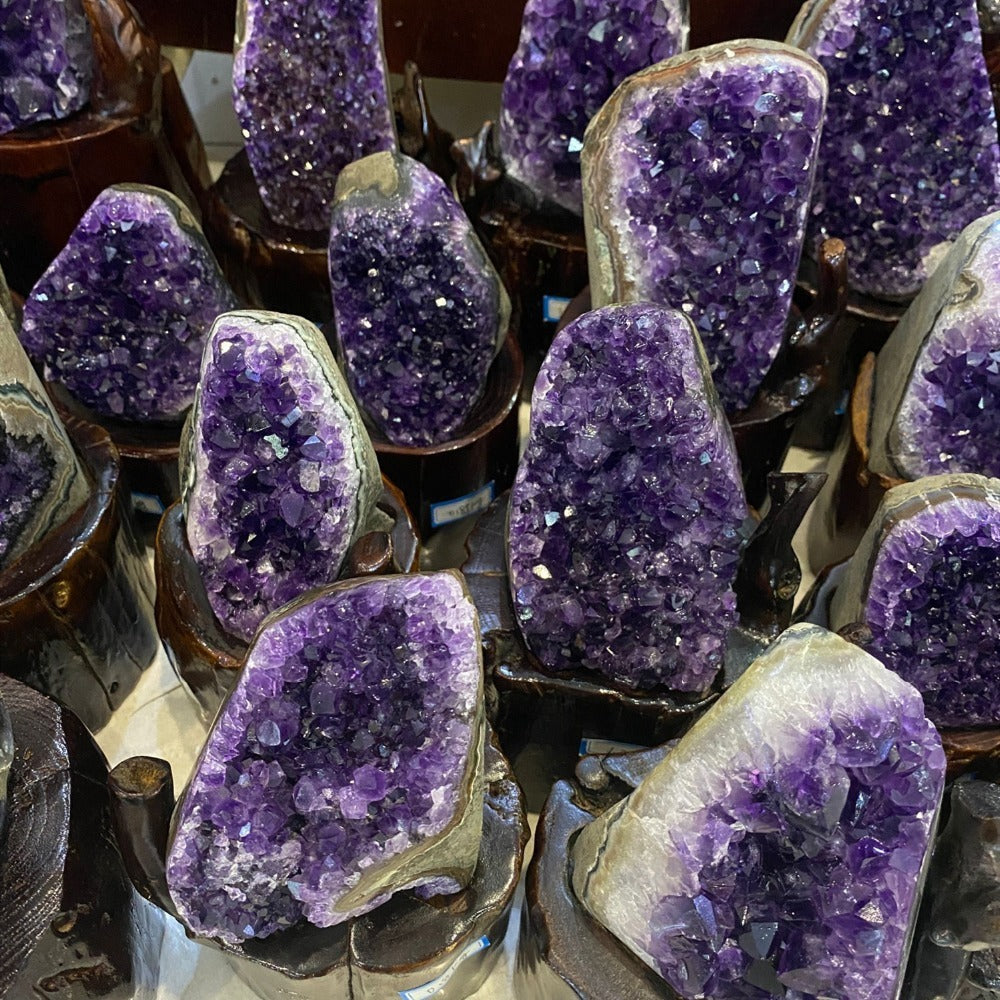 Sacred Moon Candle Co amethyst quartz cluster for energy healing display of purple geode clusters on wooden stands