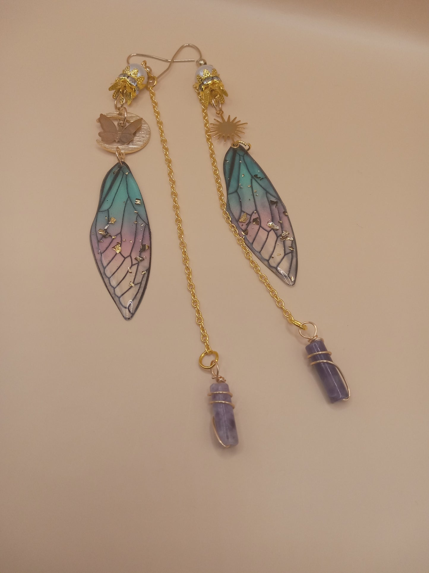 Sacred Moon Candle Co blue and violet fairy earrings with gold chains stained glass wings and amethyst point drops