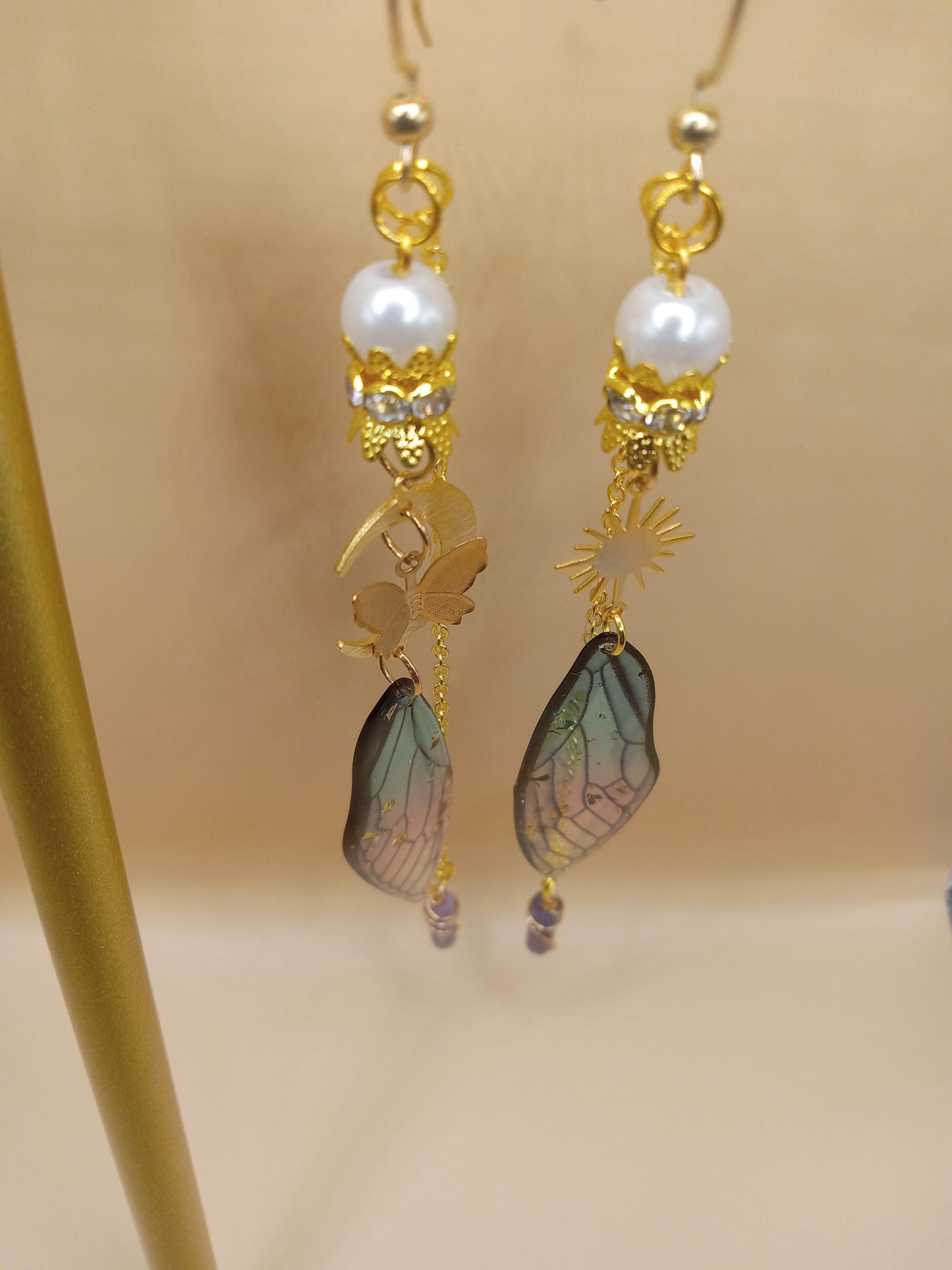 Sacred Moon Candle Co blue and violet fairy earrings with gold hooks pearl beads and iridescent fairy wings