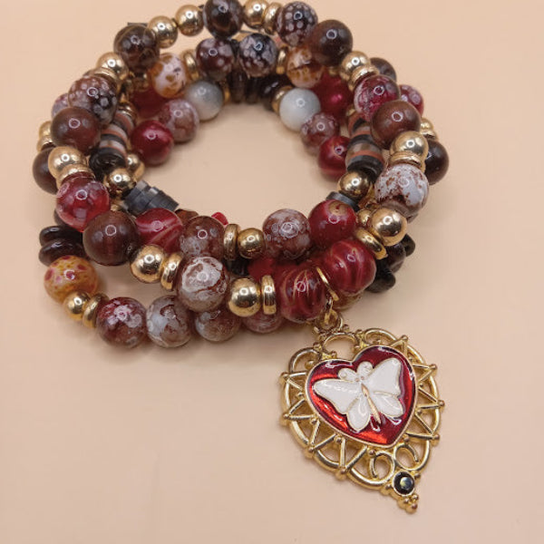 Sacred Moon Candle Co moth and flame bracelet stack with red and brown beads and gold charm