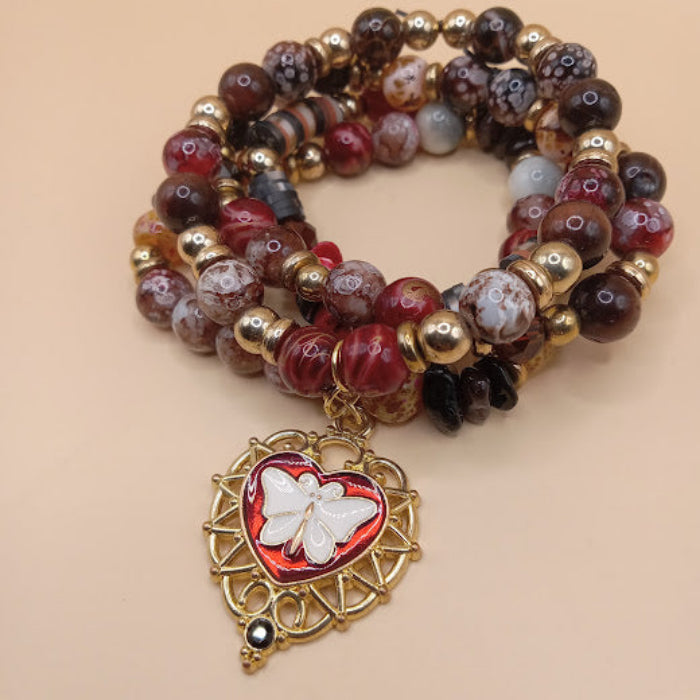 Sacred Moon Candle Co moth and flame bracelet stack with red and brown beads and butterfly heart charm