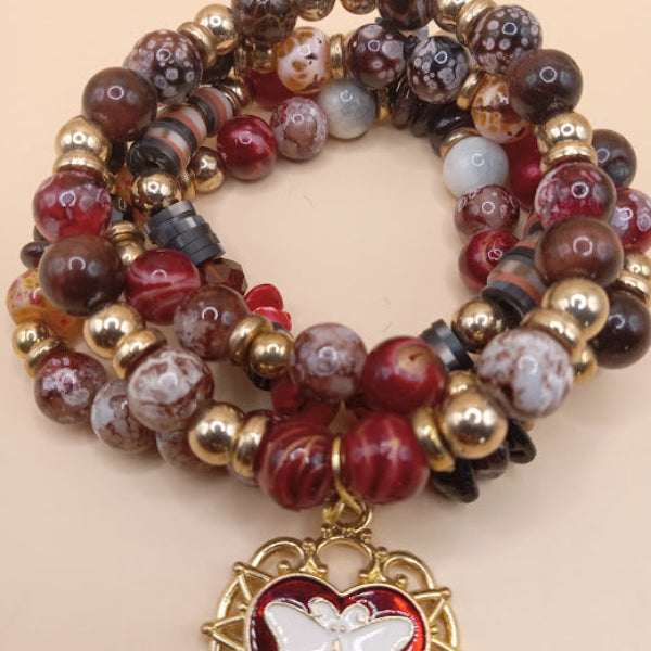 Moth and flame bracelet stack by Sacred Moon Candle Co with red, brown, and gold beads and butterfly charm
