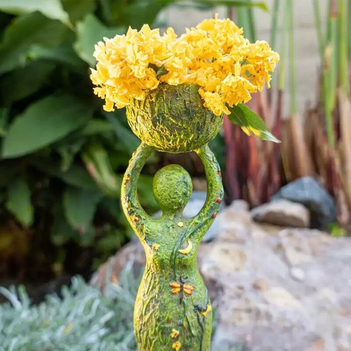 Green goddess altar statue holding a textured bowl of yellow flowers garden altar decor