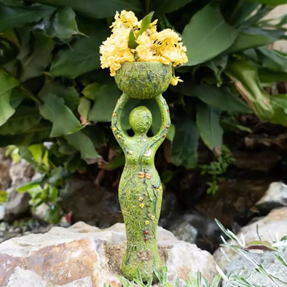 Green goddess altar statue holding a mossy bowl of yellow flowers textured vine details