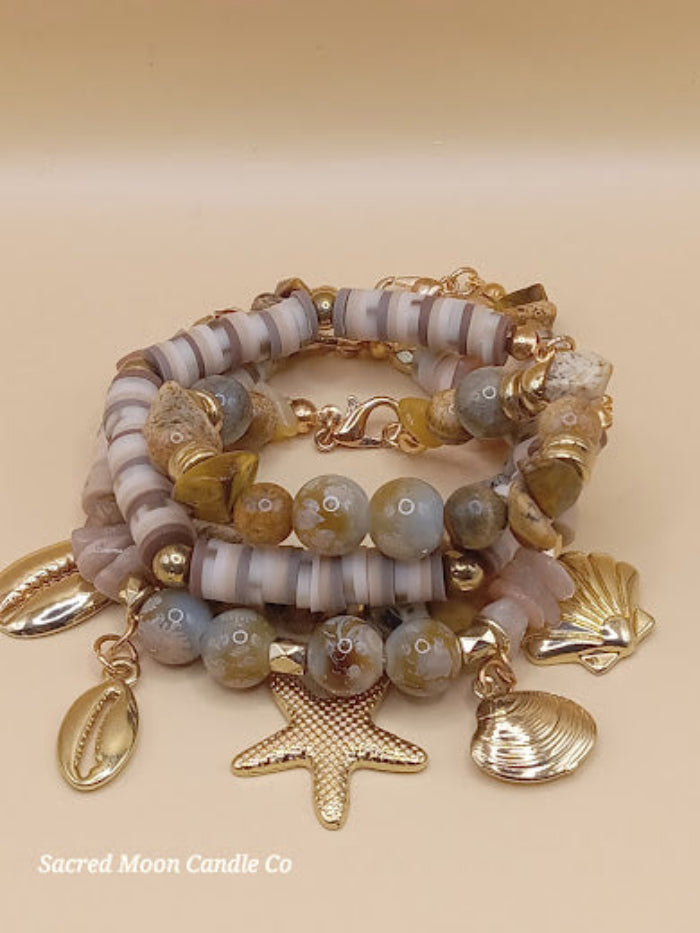 Bohemian natural stone bracelet stack with gold charms including starfish and shell by Sacred Moon Candle Co