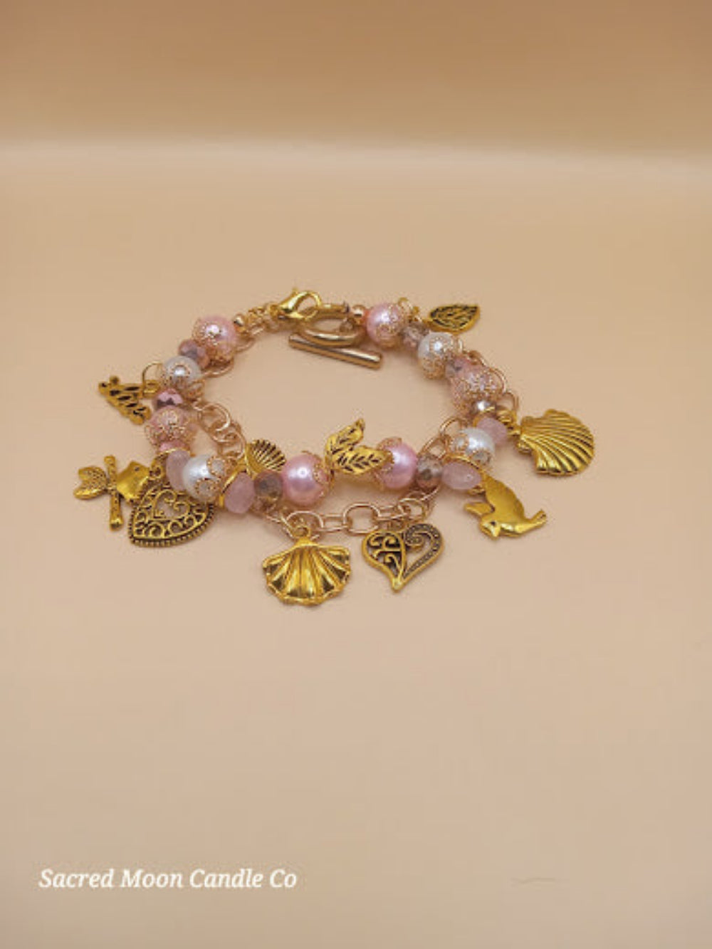 Aphrodite bracelet set by Sacred Moon Candle Co featuring gold charms and pink pearl beads bracelet stack