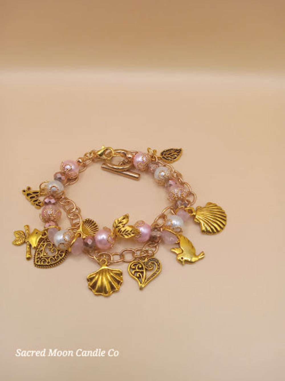 Aphrodite bracelet set by Sacred Moon Candle Co featuring gold charms and pink pearl beads