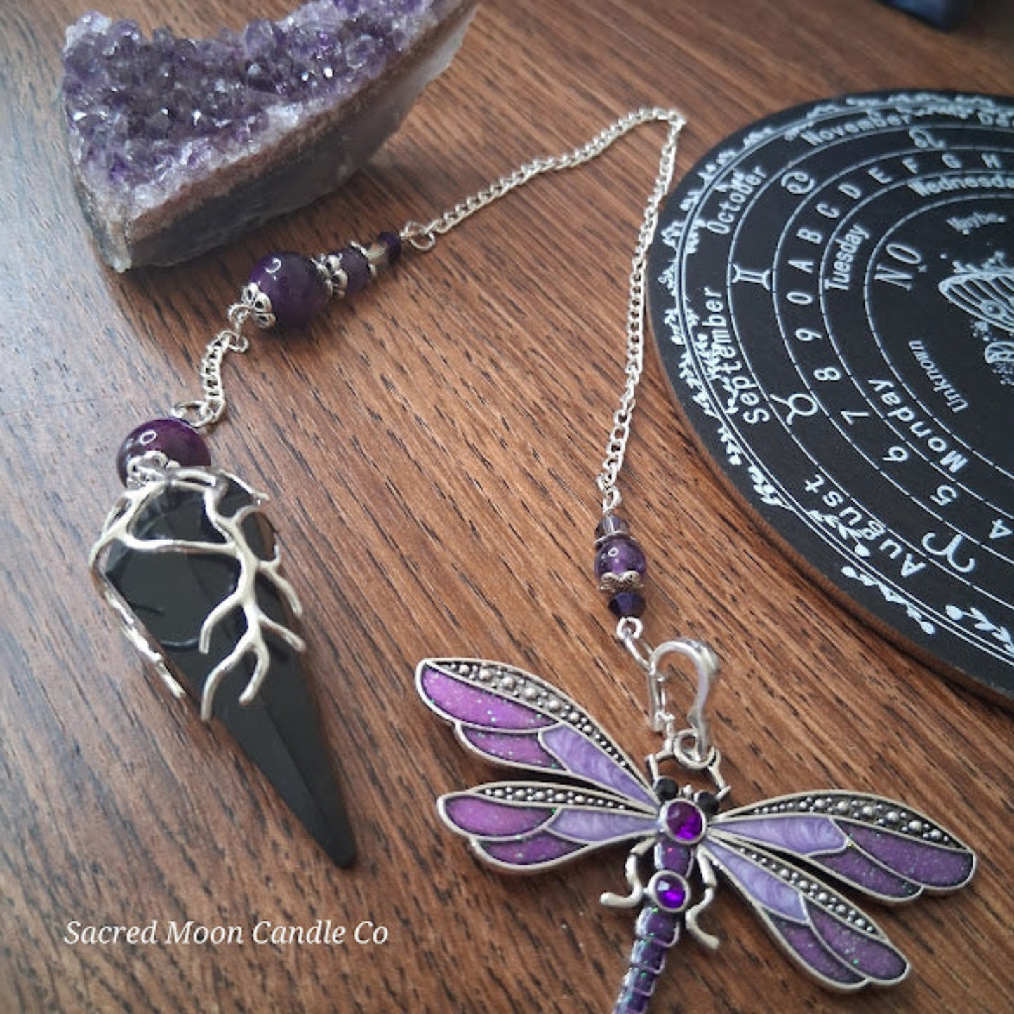 Black tourmaline Purple Tigers Eye Dragonfly Pendulum altar tool by Sacred Moon Candle Co on wood surface