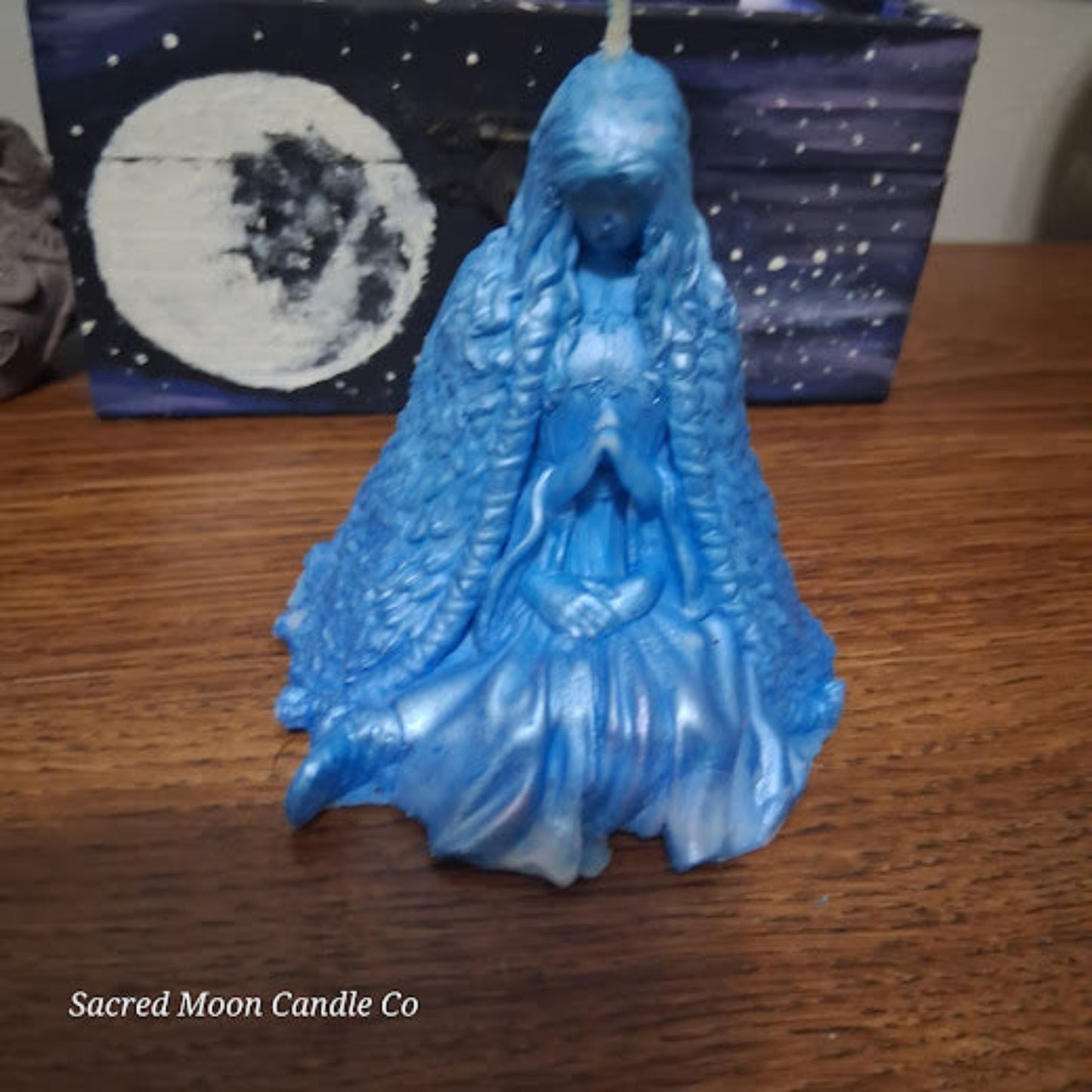 Blue Whispering Water Lily Goddess Candle 3.3oz . Hand poured goddess candle on wooden table with moon art background