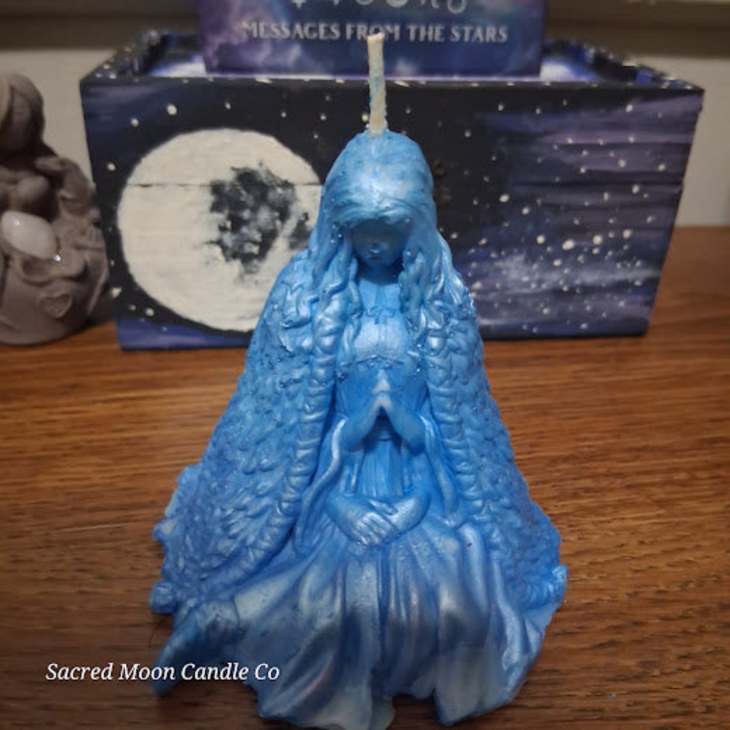 Blue Whispering Water Lily Goddess Candle 3.3oz . Sacred Moon Candle Co blue goddess prayer figurine candle on wooden table