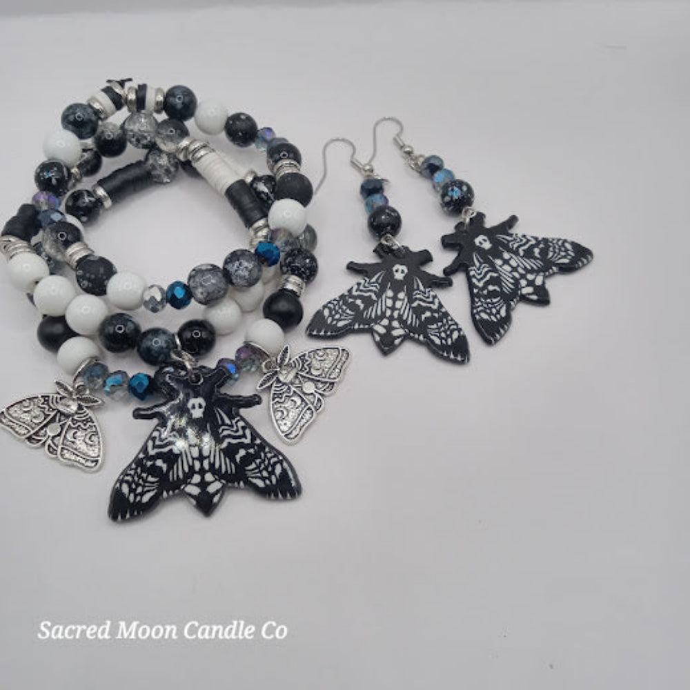 Lunar moth jewelry set by Sacred Moon Candle Co featuring black and white beaded bracelet and matching moth earrings