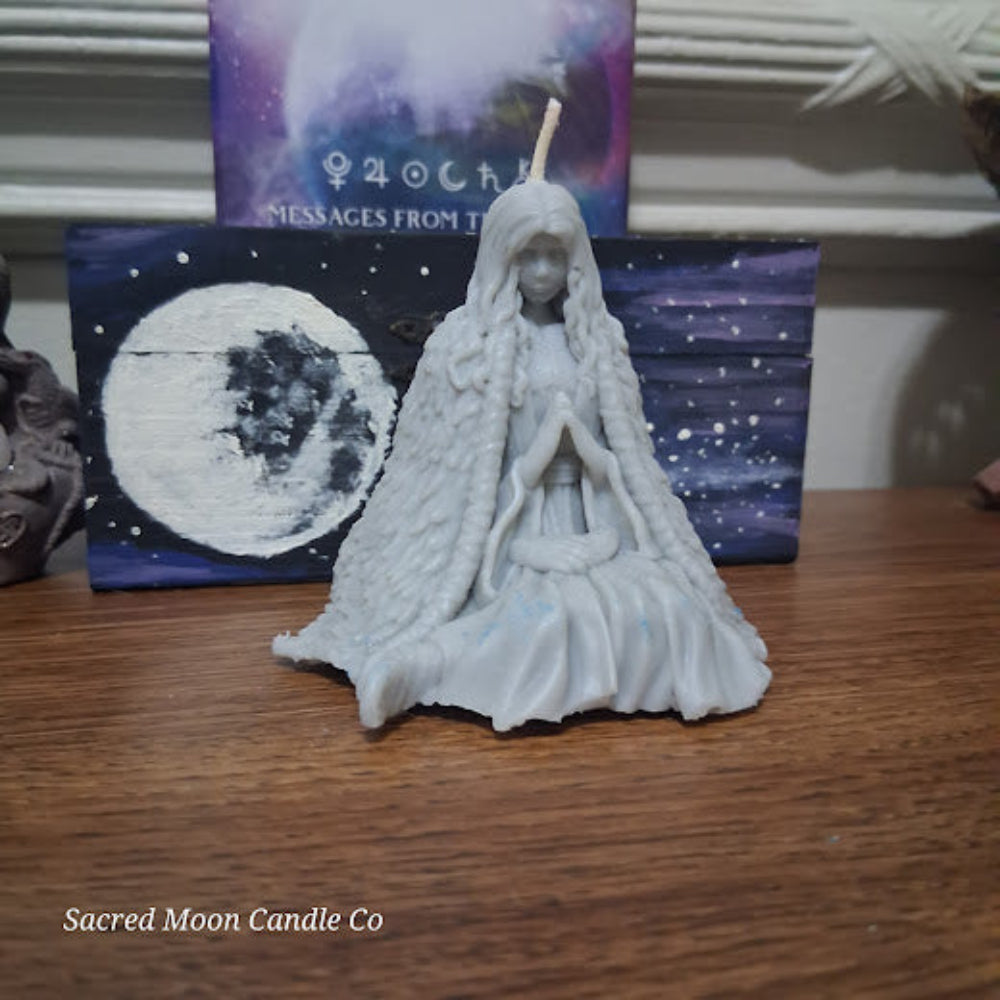 Mother Earth goddess candle by Sacred Moon Candle Co sculpted white goddess figure with cloak and moon art backdrop