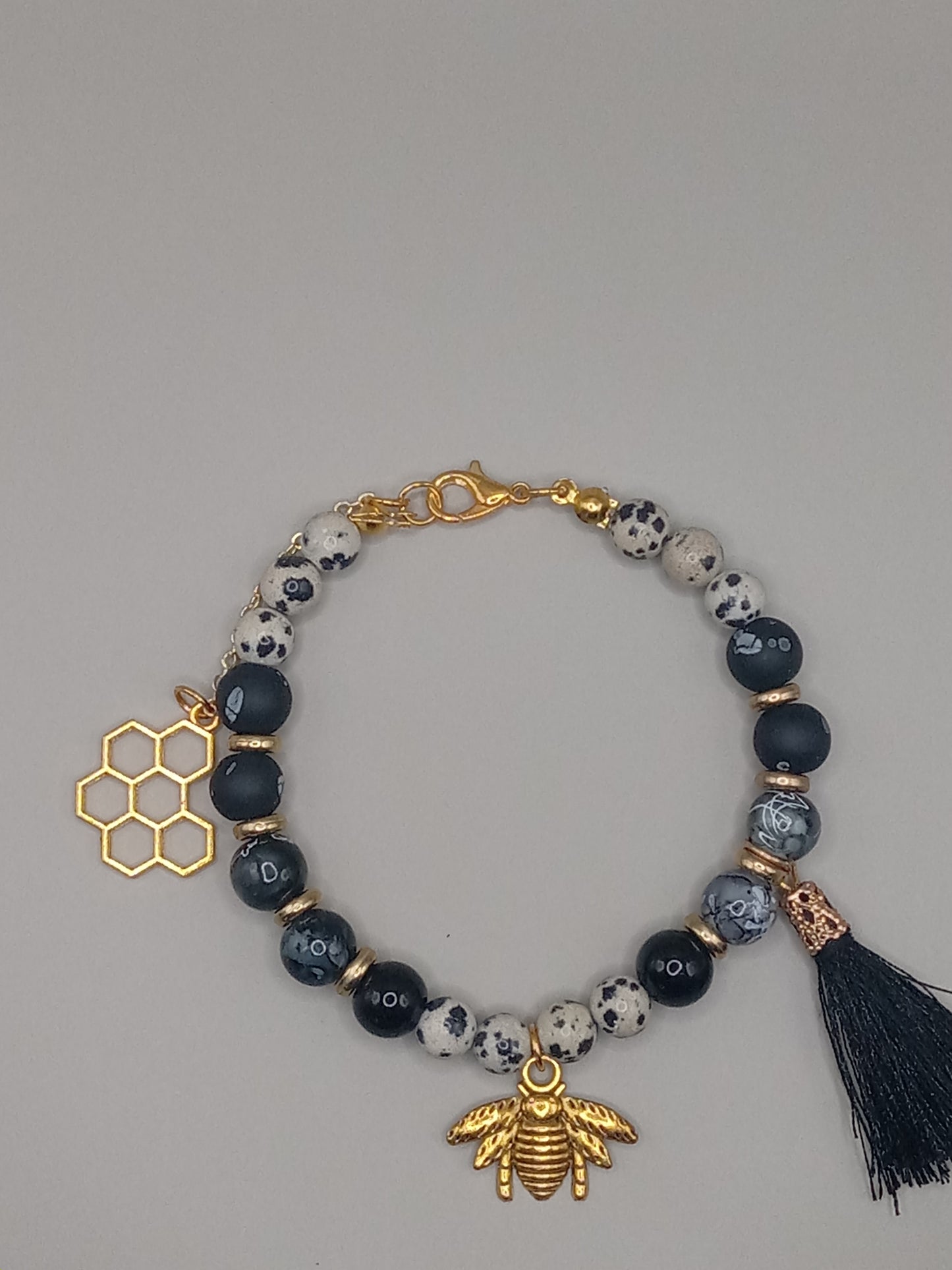 One with Nature Bohemian Dalmatian Jasper Bracelet Stack with gold bee charm honeycomb charm and black tassel plus spotted beads