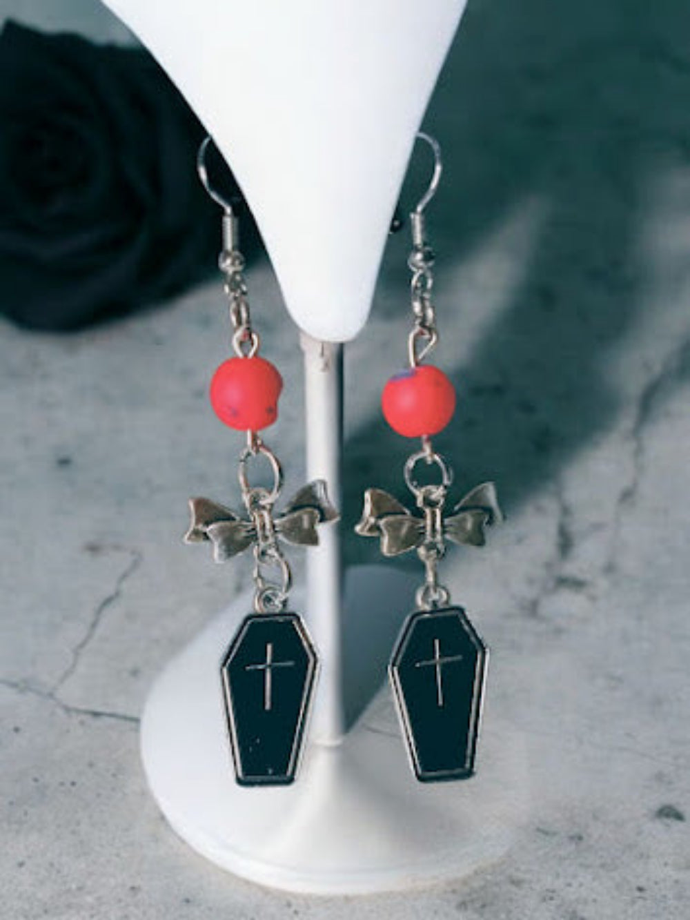 Coffin and bow dangle earrings featuring black coffin charms with crosses and red beads