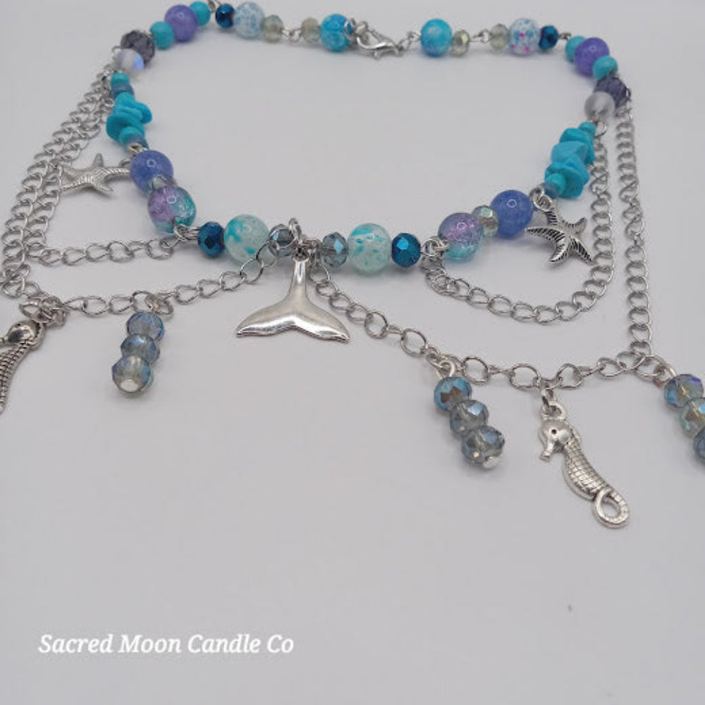 Sacred Moon Candle Co mermaid tail choker necklace with blue beads and silver sea-themed charms