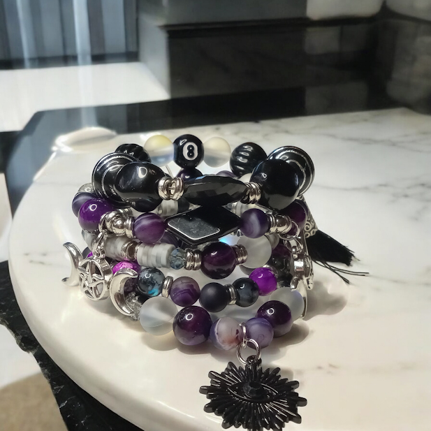 Sacred Moon Candle Co bracelet stacks featuring spiritual protection beaded bracelets with purple and black beads
