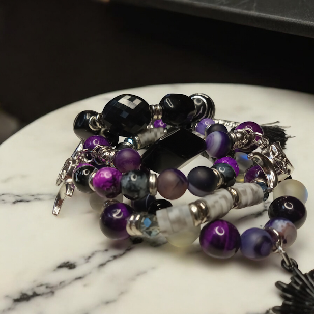 Sacred Moon Candle Co spiritual protection beaded bracelets stack with purple and black stones on marble surface