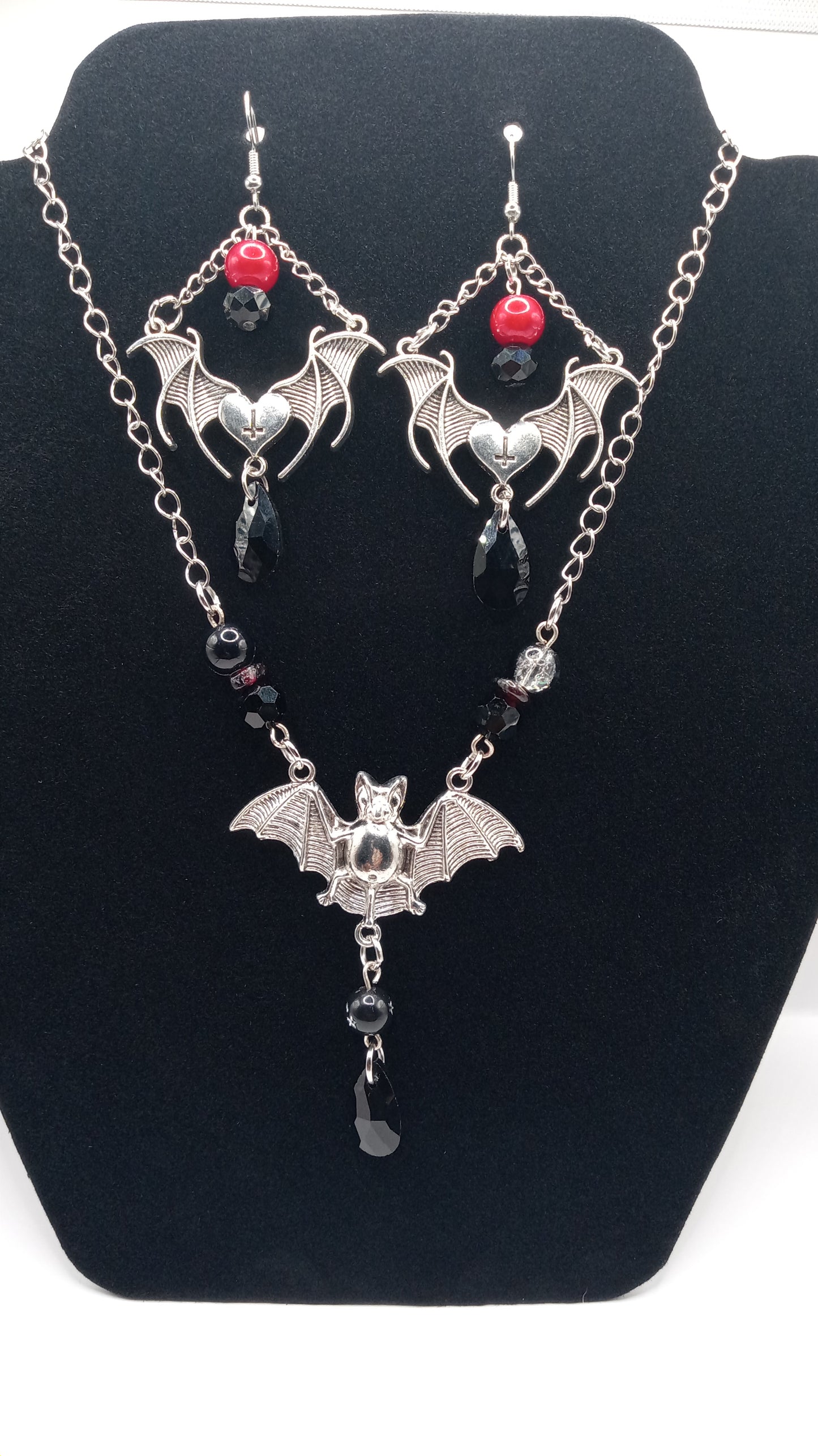 Sacred Moon Candle Co gothic bat jewelry set featuring silver bat earrings with red beads and matching necklace