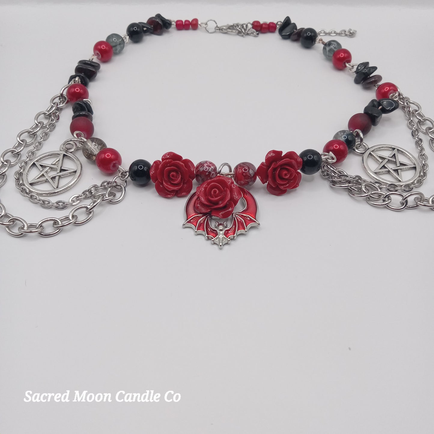 Handmade rose bat choker with red roses, black beads, silver pentagram charms, and chain details