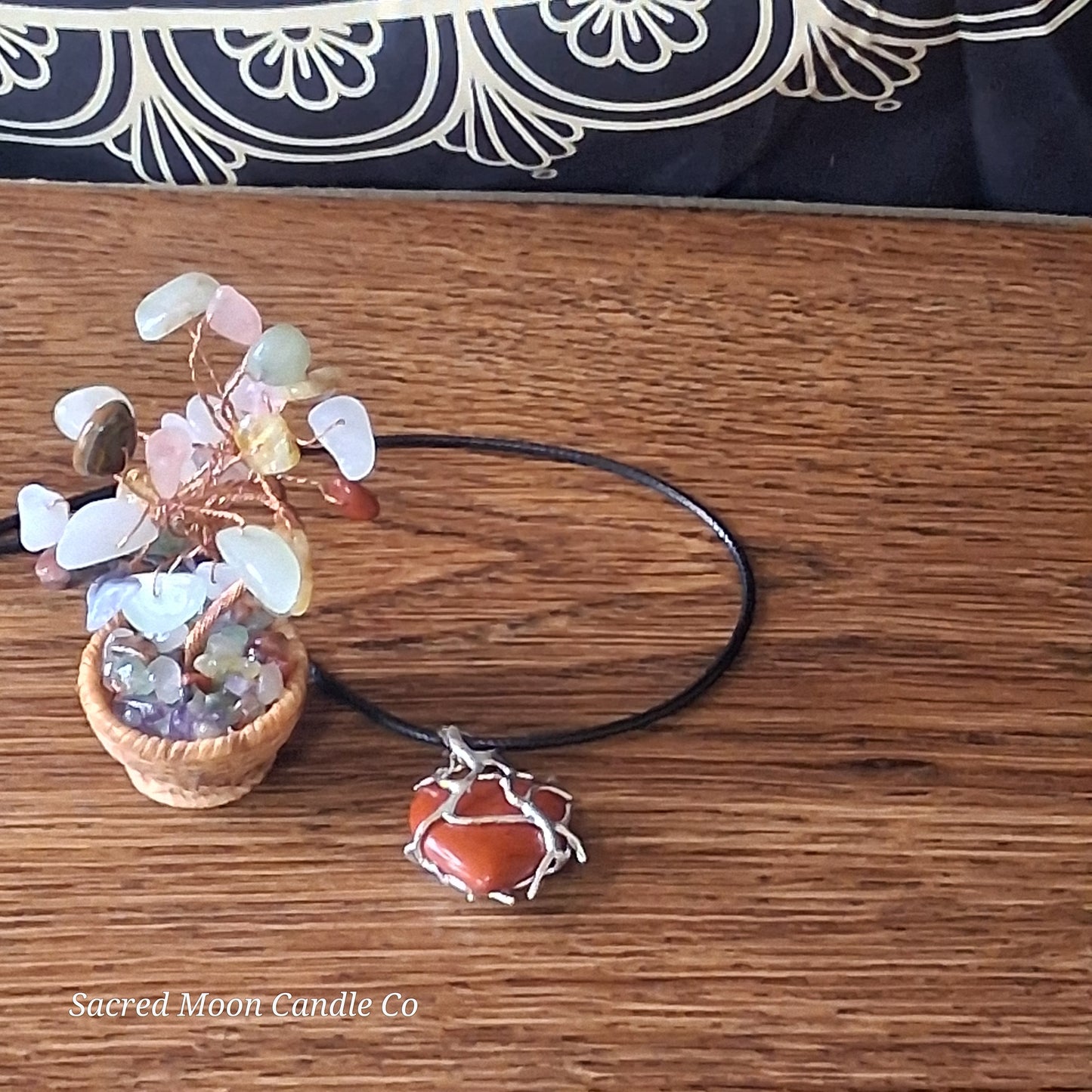 Red Jasper Tree Branch Wrapped Heart Stone Pendant black cord Necklace by Sacred Moon Candle Co on wooden surface