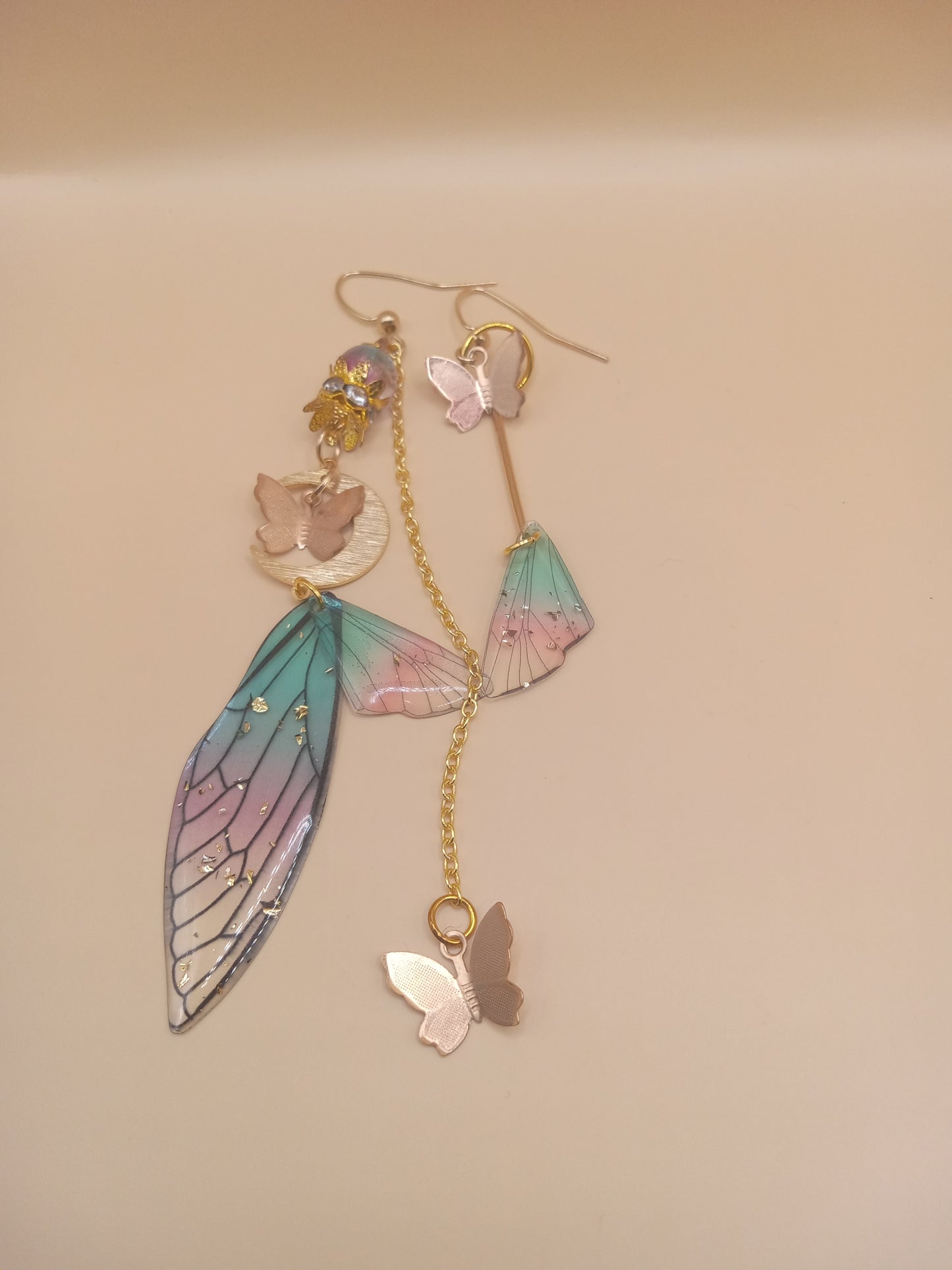 Sacred Moon Candle Co fairy wing earrings with pastel colors and gold chain details