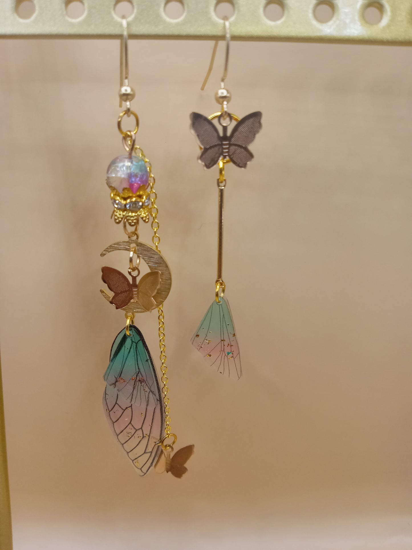 Sacred Moon Candle Co fairy wing earrings with colorful wing designs and gold accents, handmade and unique
