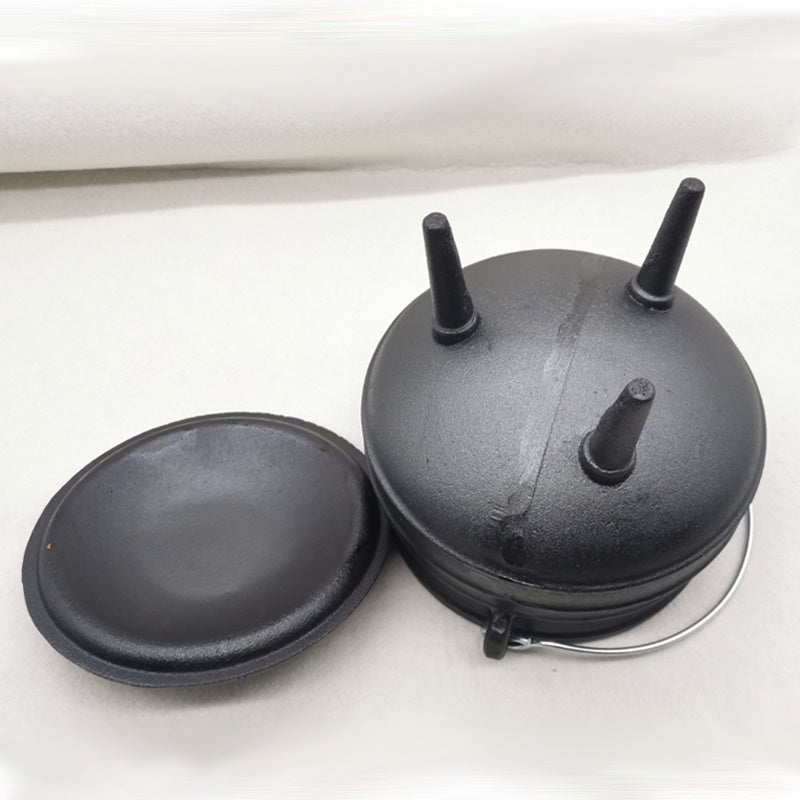 Three-legged cast iron cauldron from Sacred Moon Candle Co with removable lid and sturdy handle
