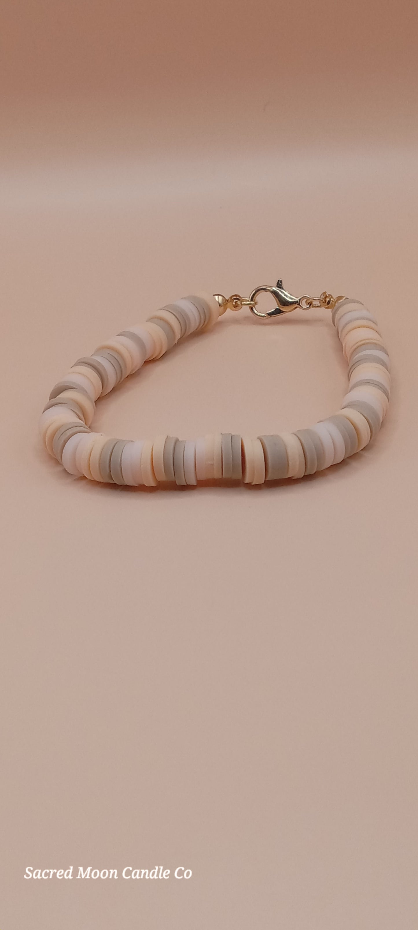 Sacred Moon Candle Co bracelet stacks featuring a witchy cat charm bracelet with neutral tone beads and gold clasp