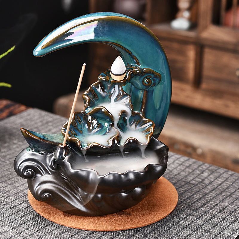 Sacred Moon Candle Co ceramic moon backflow incense burner with teal crescent waterfall smoke and incense stick holder