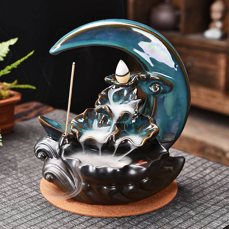 Sacred Moon Candle Co ceramic moon backflow incense burner with teal crescent and cascading smoke effect