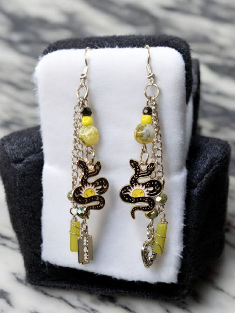 Sacred Moon Candle Co snake charm earrings with yellow beads and dangling silver chains