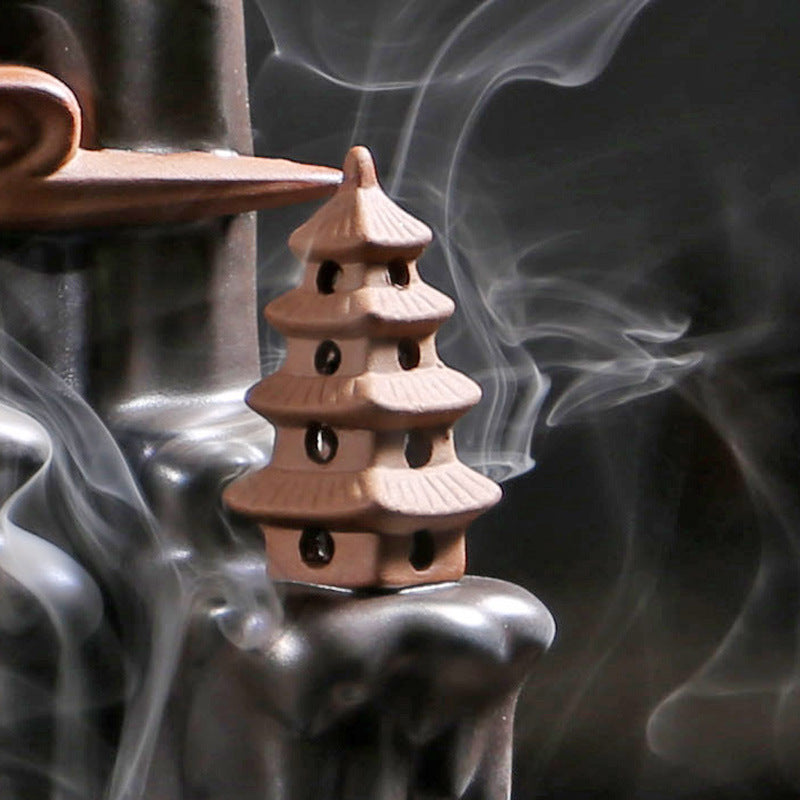 Black backflow incense burner with pagoda design creating flowing smoke effect