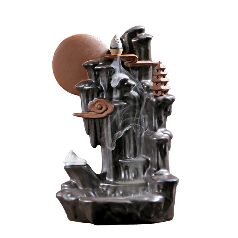 Black backflow incense burner by Sacred Moon Candle Co with cascading smoke and decorative elements