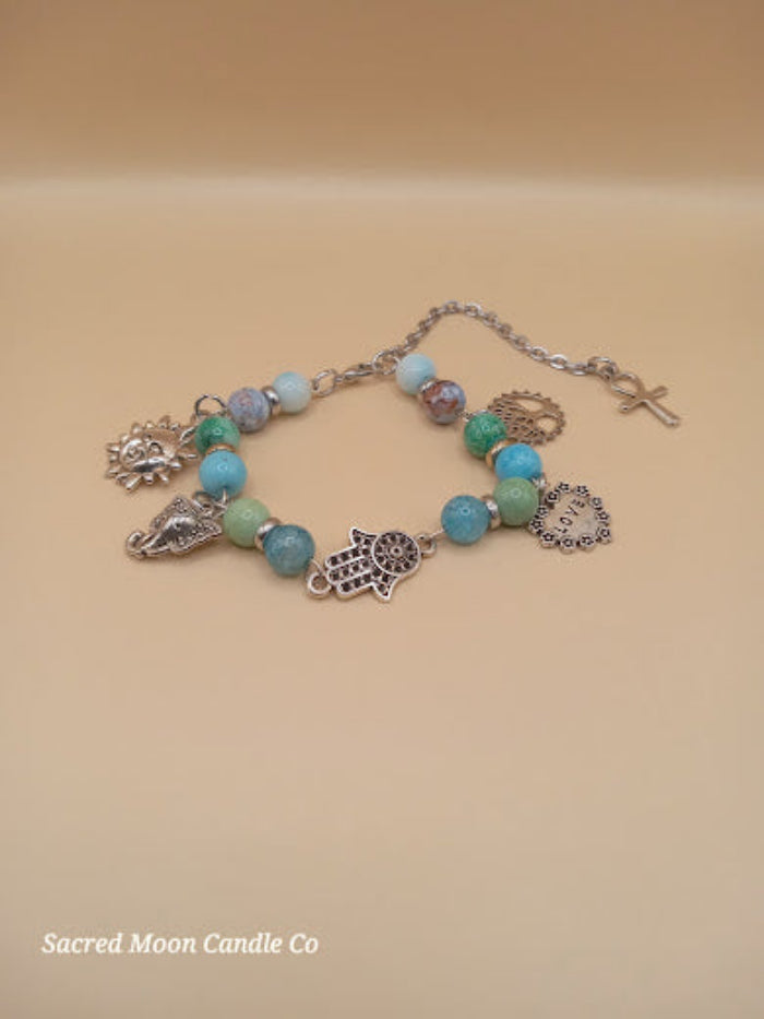 Bohemian beach crystal bracelet stack by Sacred Moon Candle Co with blue and green beads and silver charms