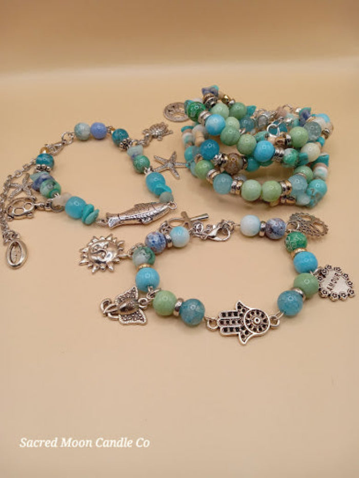Bohemian beach crystal bracelet stack by Sacred Moon Candle Co featuring silver charms and blue green beads