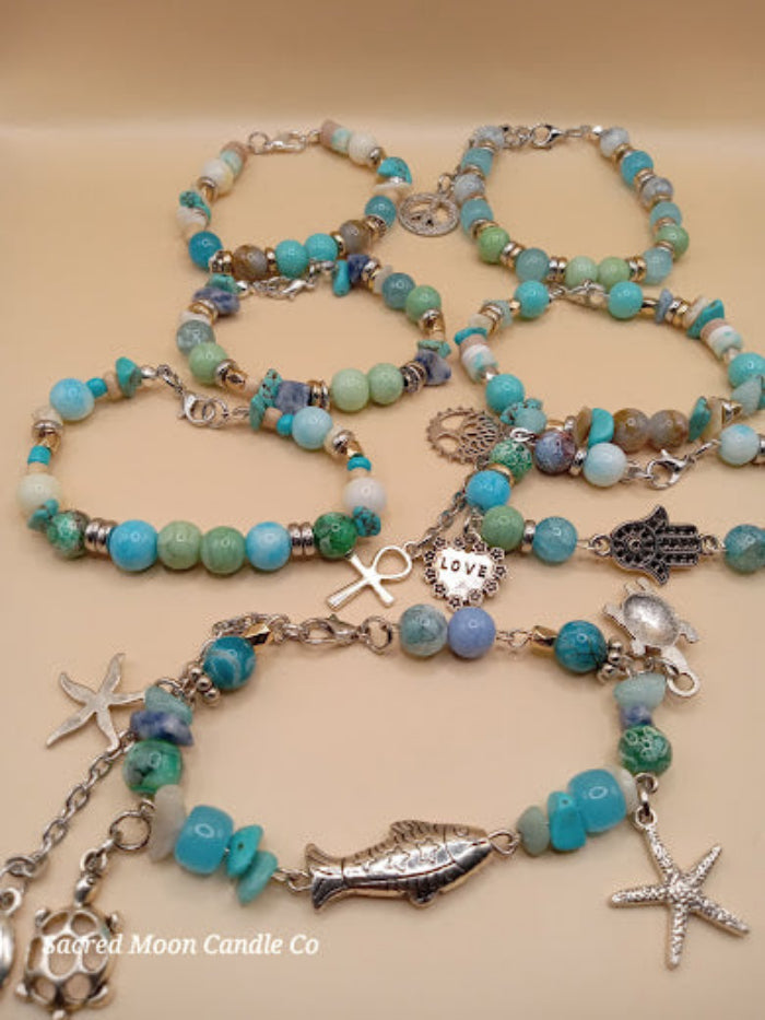 Bohemian beach crystal bracelet stack by Sacred Moon Candle Co featuring turquoise and green beads with silver charms