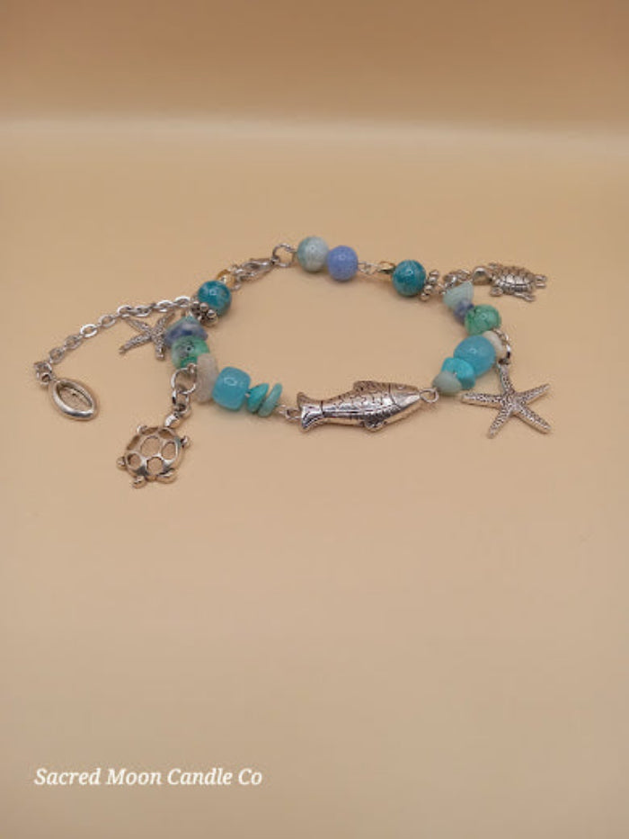 Bohemian beach crystal bracelet stack with silver fish and starfish charms by Sacred Moon Candle Co
