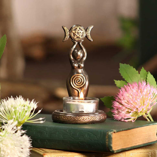 Bronze goddess altar statue with spiral belly and pentacle triple moons triple moon goddess tea light candle holder on green book