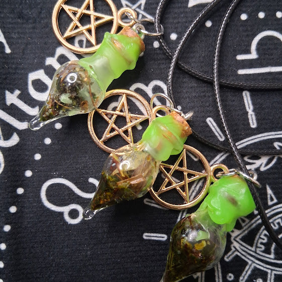 Prosperity spell bottle necklace with green glass vial and gold pentagram charm on black cord
