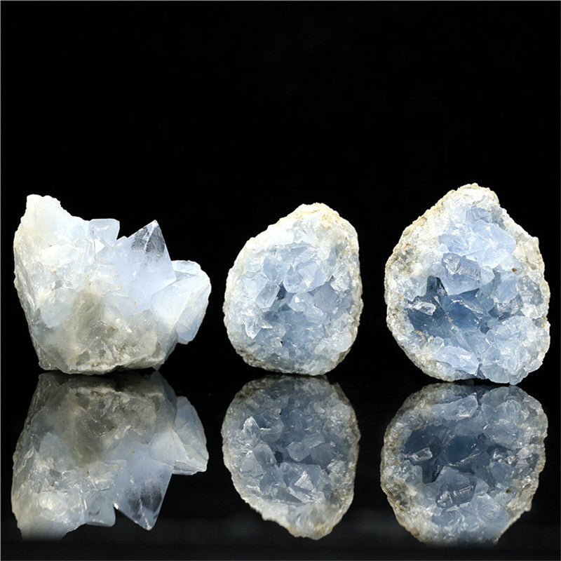 Sacred Moon Candle Co celestite kyanite crystal stone trio of light blue geode clusters on black reflective surface