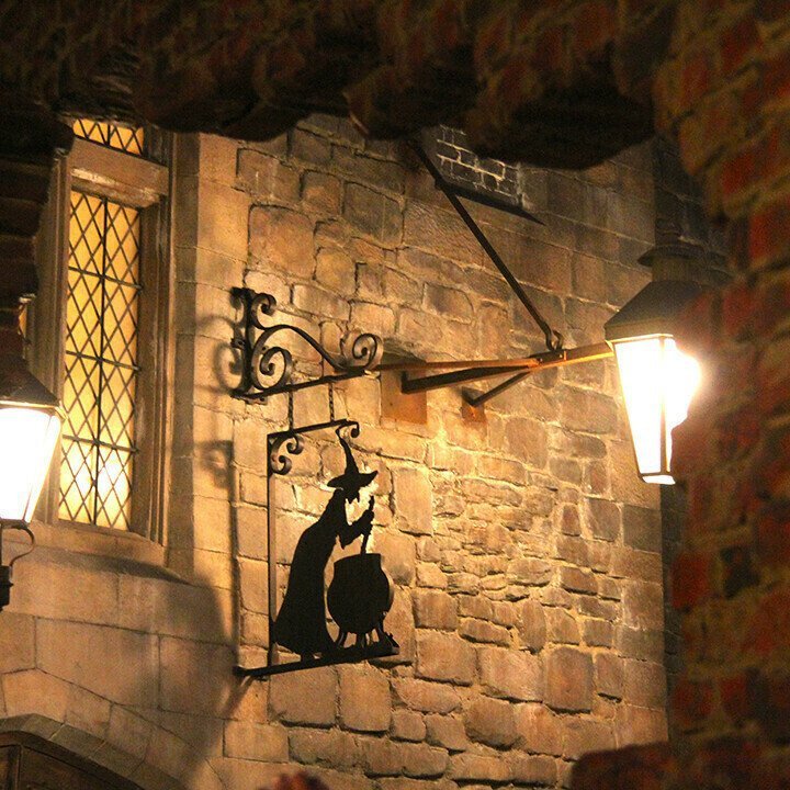 Sacred Moon Candle Co witch cauldron metal wall art silhouette of witch brewing potion on stone wall