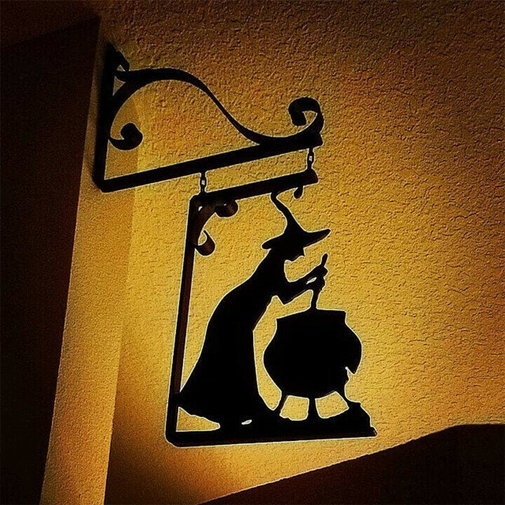 Witch cauldron metal wall art hanging silhouette with a witch stirring a cauldron on textured wall