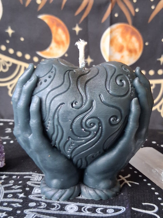 Heart in hands candle by Sacred Moon Candle Co with intricate swirling patterns in dark gray