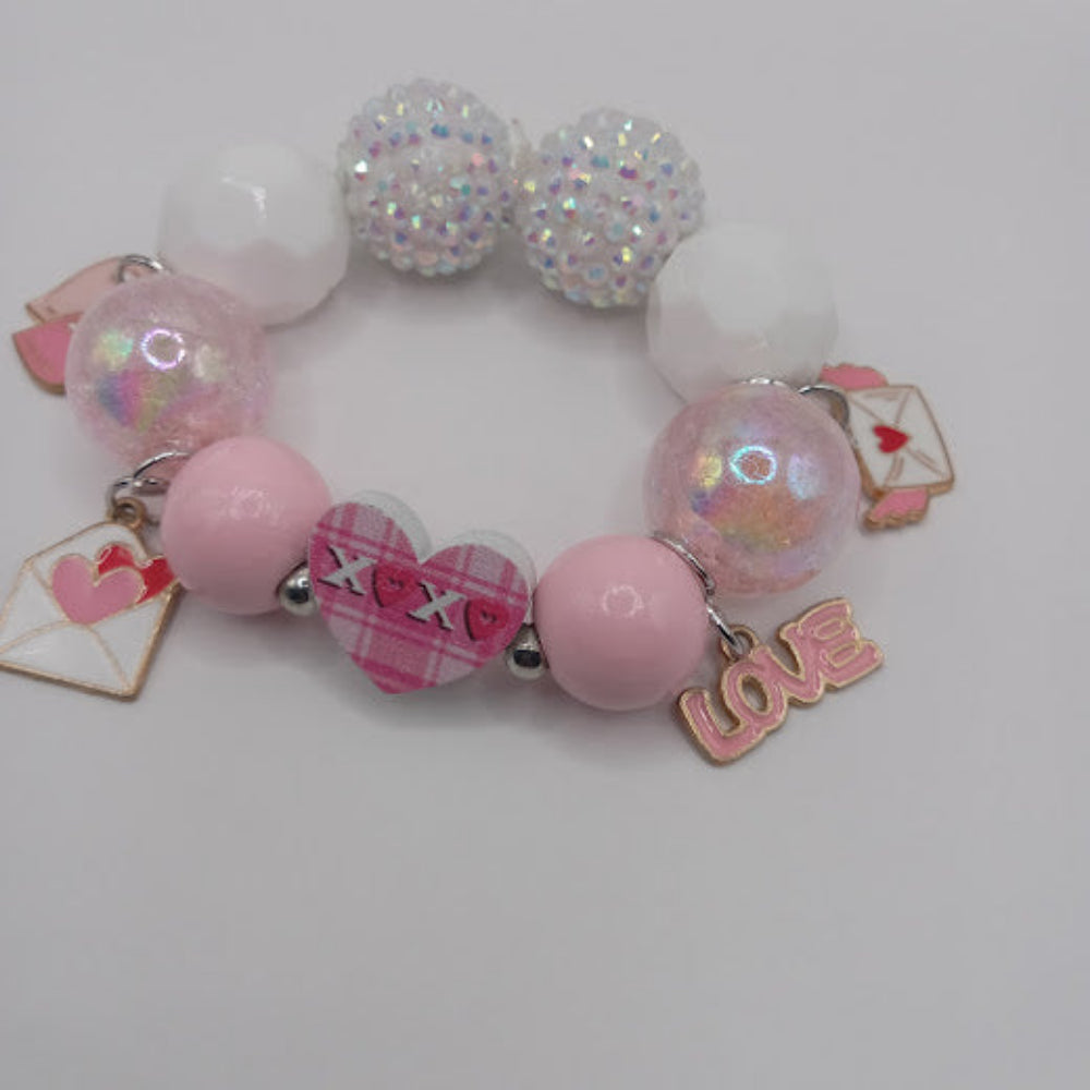 Sacred Moon Candle Co bracelet featuring hugs and kisses heart jewelry with pink and white beads and love charms