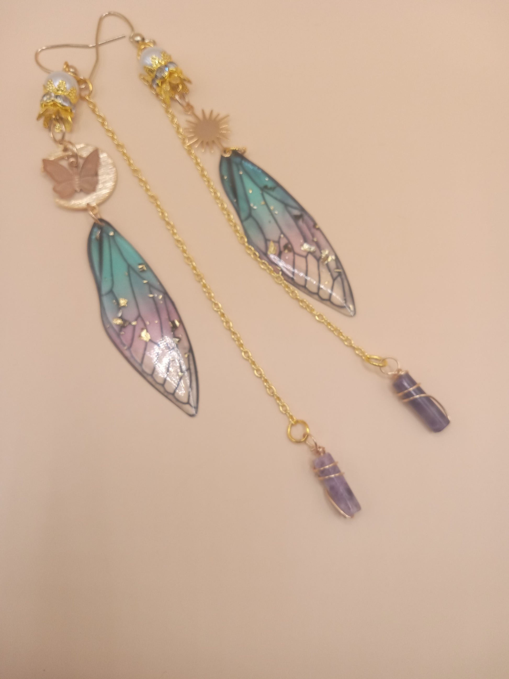 Sacred Moon Candle Co blue and violet fairy earrings with gold filigree fairy wings and amethyst dangle