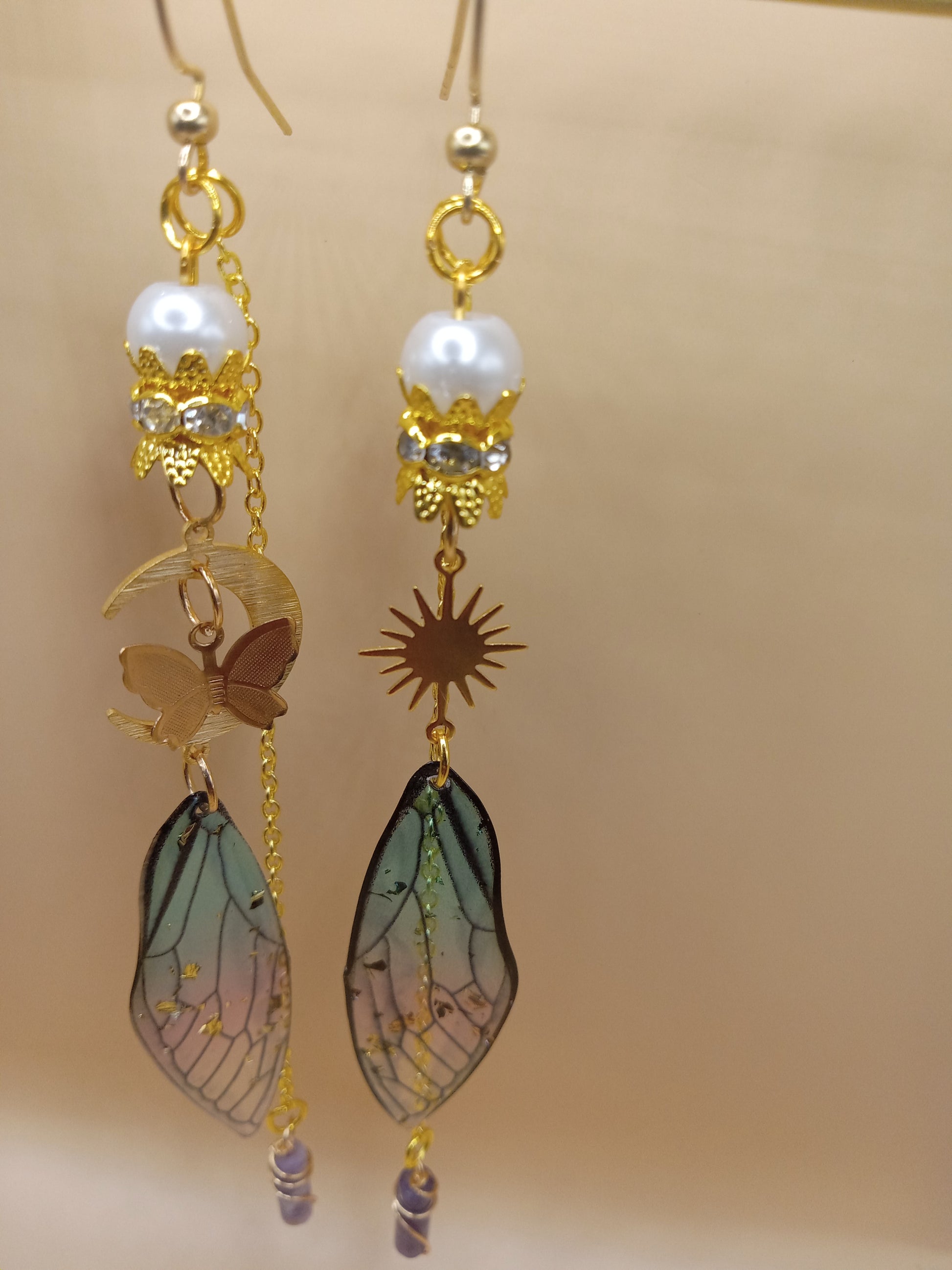 Sacred Moon Candle Co blue and violet fairy earrings with gold hooks pearl accents sun and moon charms wing dangles
